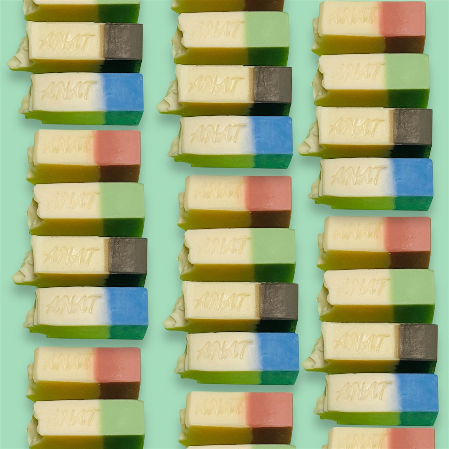 Handmade plant-based soap bars featuring a two-tone design embossed with the brand name ANAT.