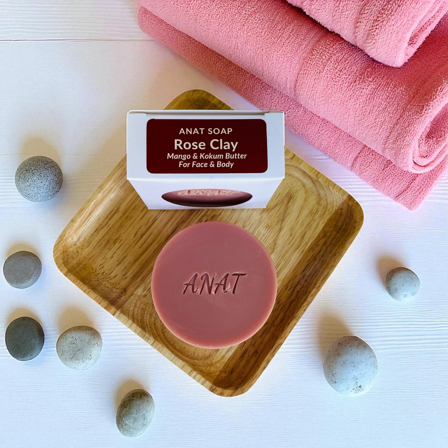 Anat Soap Rose Clay round handmade plant-based soap bar with mango and kokum butters for face and body, shown on a bamboo soap dish next to the product box.