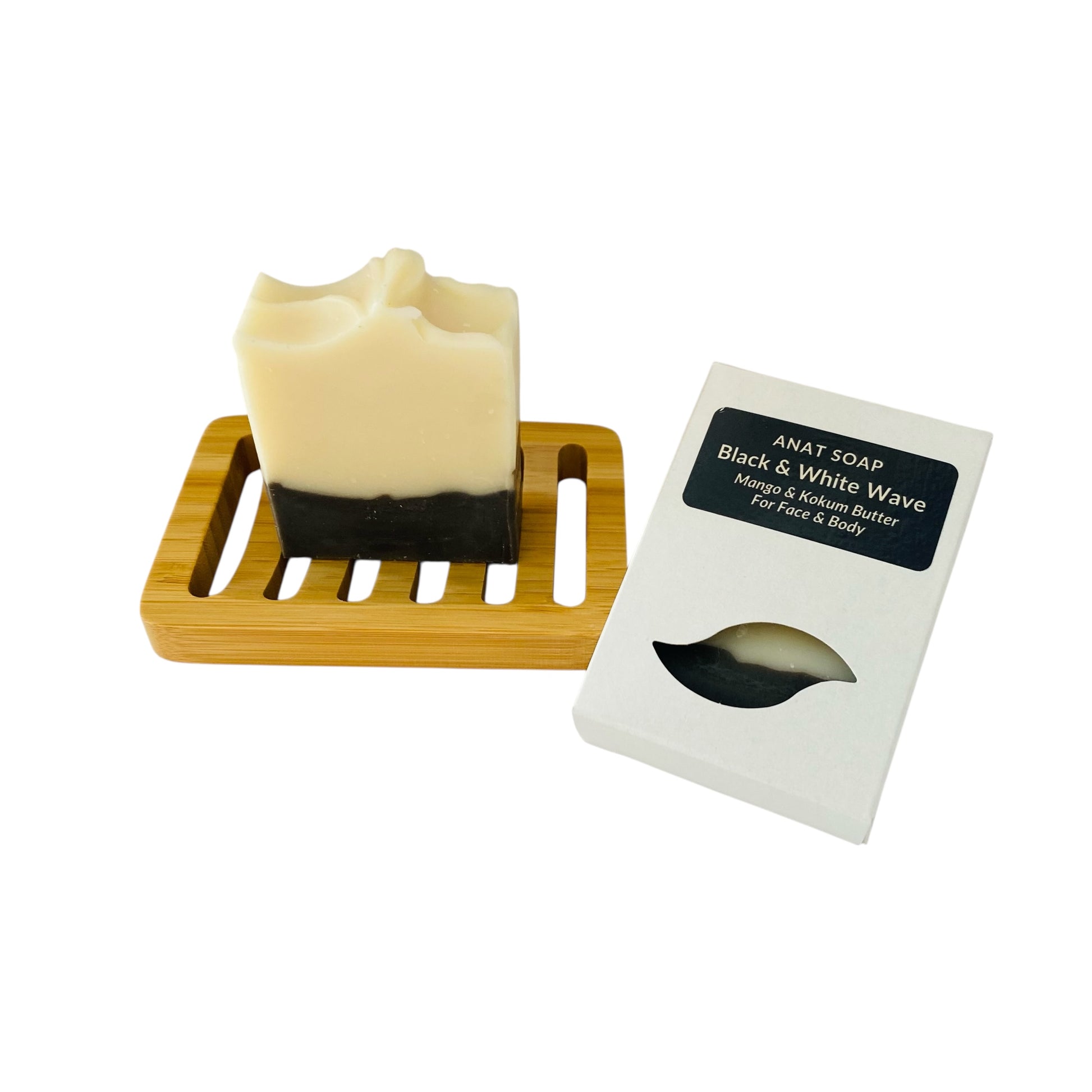 Anat Soap Black Wave handmade plant-based soap bar with mango and kokum butter for face and body, shown on a bamboo soap dish next to the product box.