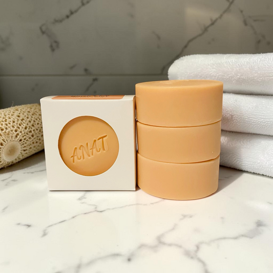 Anat Soap Blush Clay round handmade plant-based soap bar with mango and kokum butters for face and body, shown next to the product box.